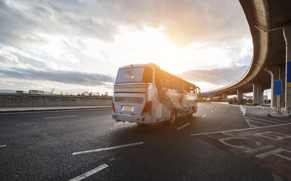 The bus is standing in the parking lot at sunset.