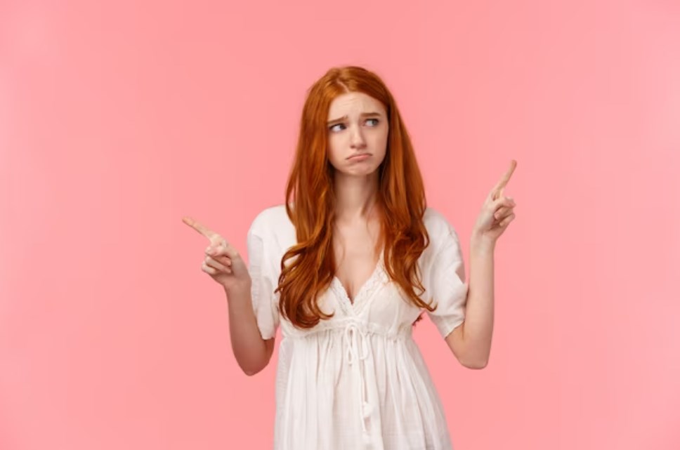 an indecisive redhead girl that doesn't know what to do while standing in a pink background