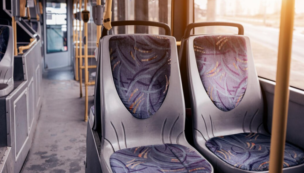 public bus with colorful blue seats and yellow handrails